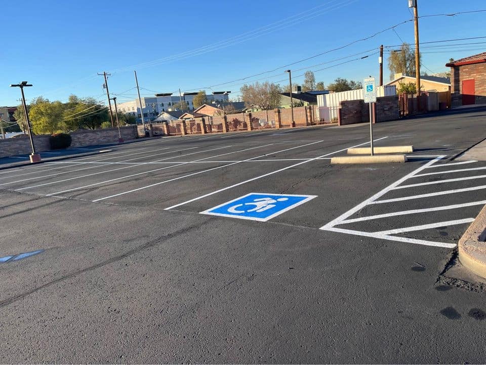 Asphalt worker spreading seal coat on a parking lot in San Antonio TX